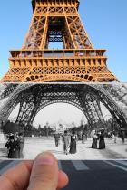 Someone holding old photograph of Eiffel Tower in front of Eiffel Tower