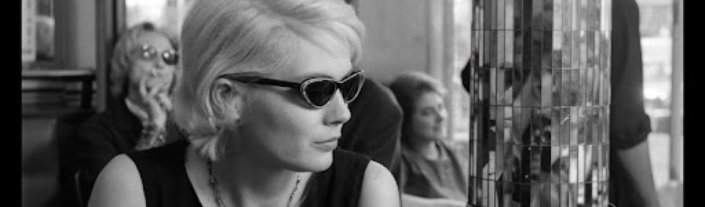 Blonde woman with sunglasses sitting in cafe